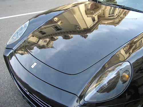 Das Casino von Monte Carlo spiegelt sich in der Motorhaube eines Luxuswagens