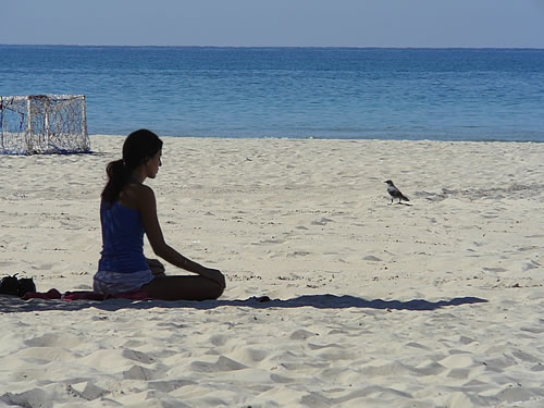 Junge Israelin die am Strand meditiert